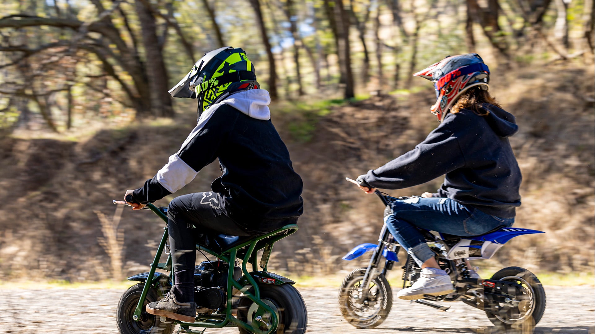 Two boys are riding the dirt bikes.