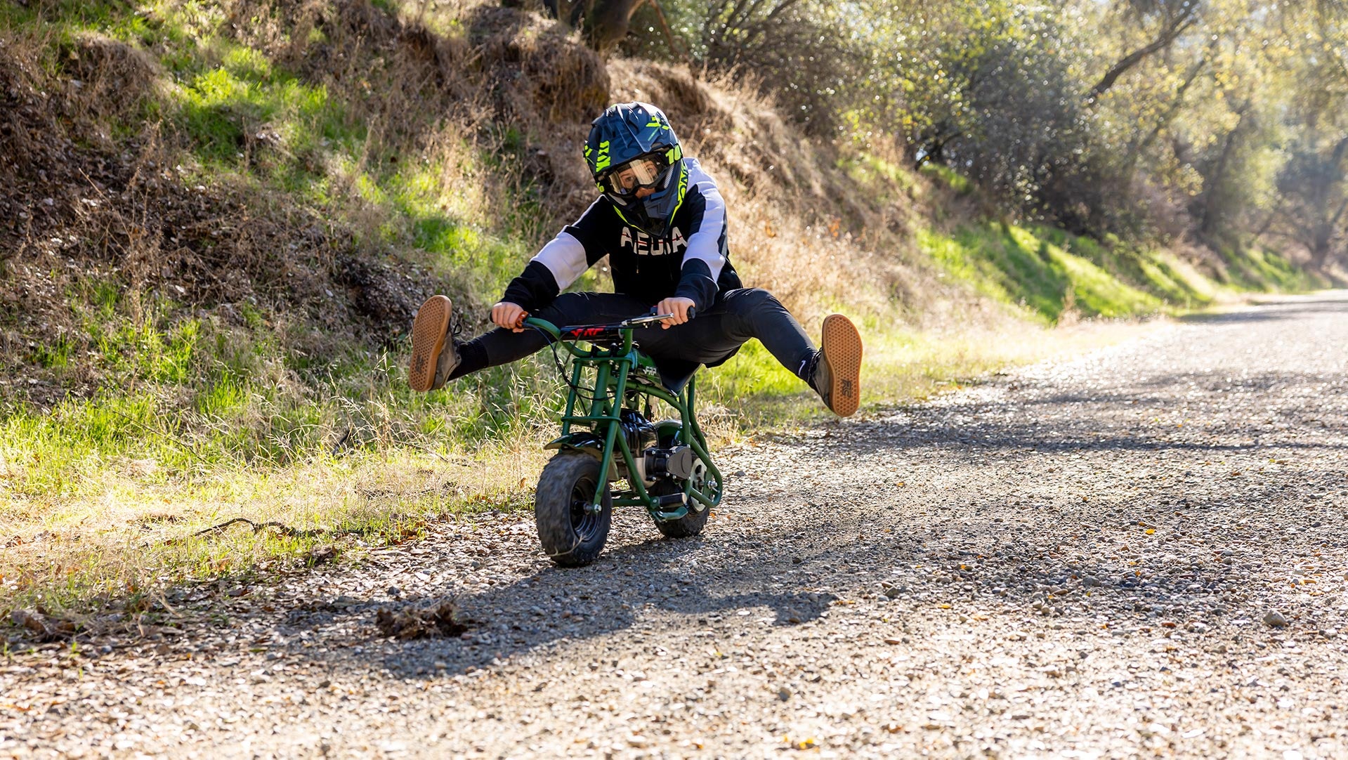 A boy is riding an FRP gas mini dirt bike.
