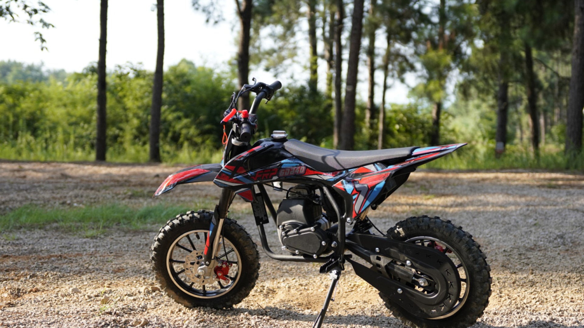 An Ogemaw 40 mini gas dirt bike is in the forest.